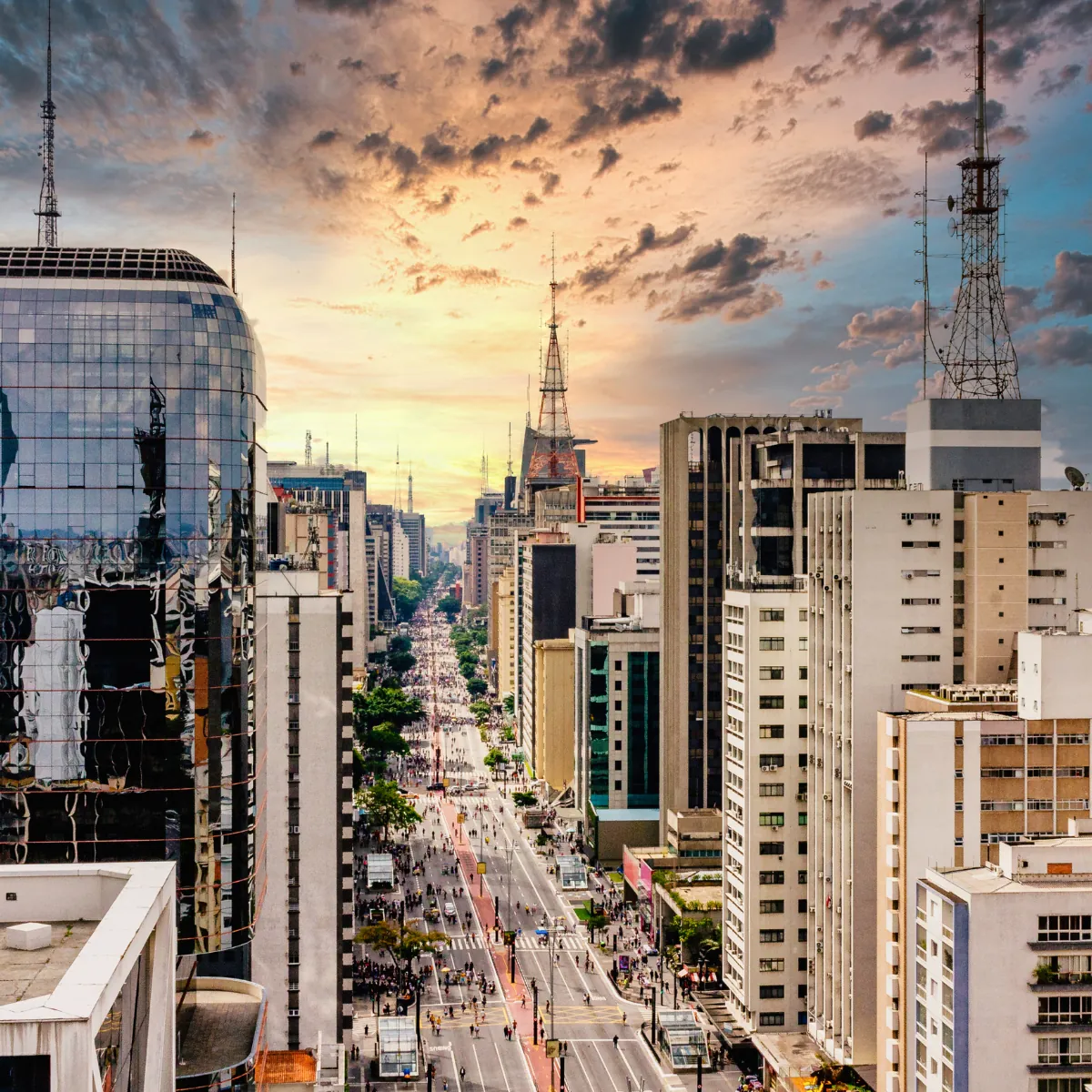 Avenida larga entre prédios vista de cima ao entardecer